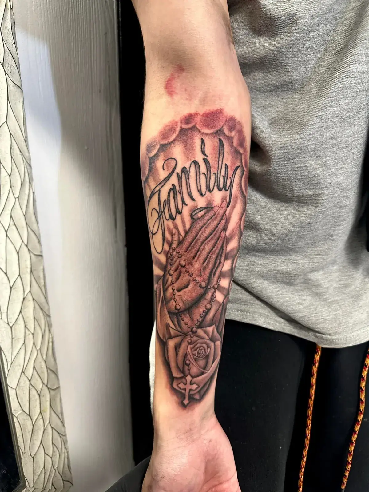 Black and grey realism prayer hands forearm tattoo